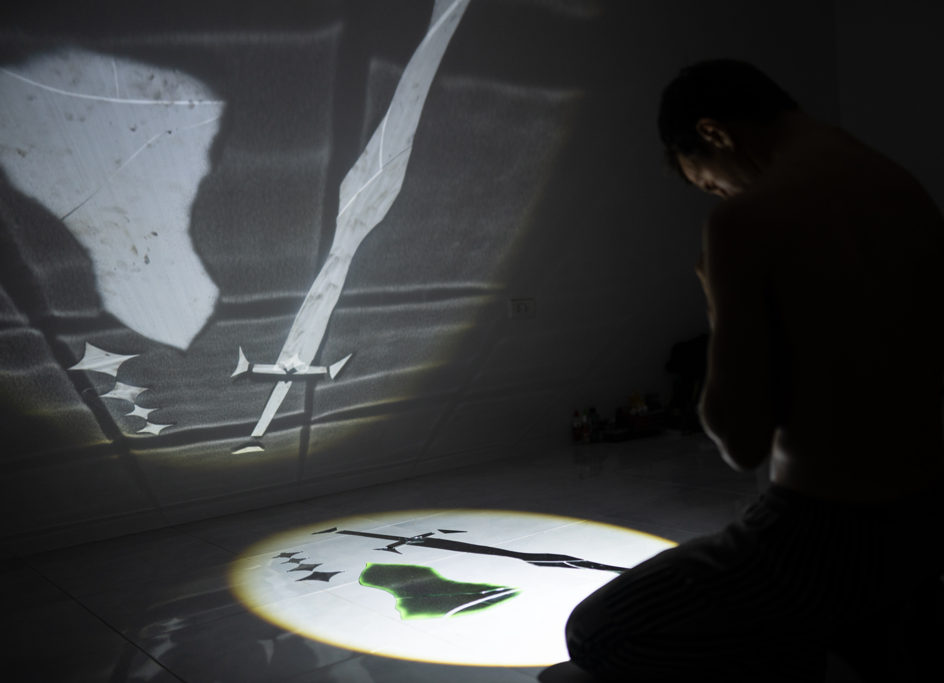 Reflected light on the wall forms a shield, a sword and four stars